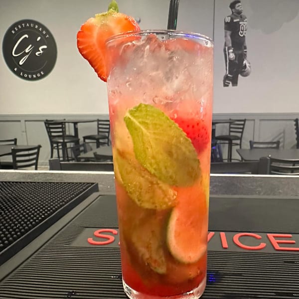 A strawberry mojito cocktail with mint and lime on a bar mat at Cy's Restaurant & Lounge.